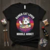 Ramen Cat Lover Noodle Addict text with a cute cat eating ramen graphic on a black t-shirt