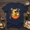 Ramen Wave Bowl Japanese Noodle Soup Tee featuring a stylized orange bowl overflowing with ramen noodles, egg, and toppings, with