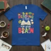 Reading Is Food For Your Brain text with cute food and book graphics on a blue t-shirt