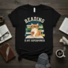 Reading Is My Superpower t-shirt design with a cute cat wearing glasses and holding a coffee mug, sitting on a