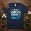 Navy blue t-shirt with "REAL GOLFERS ARE BORN IN April" text in white and blue, celebrating April birthdays for golfers