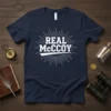 Navy blue t-shirt with white "REAL McCOY" text in a vintage sunburst graphic