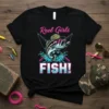 Reel Girls FISH! text with a bass fish, sunglasses, and fishing rods graphic on a black t-shirt