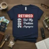 Retired 2019 Not My Problem Anymore text design on a navy t-shirt, featuring bold white lettering and a red banner
