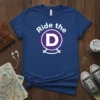 Ride the D political statement t-shirt design featuring bold white text and a purple D logo on a blue shirt