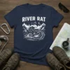 River Rat t-shirt featuring a kayaker navigating a large wave, with a rat on top, surrounded by mountains and trees