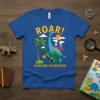 Roar! Explore! Discover! text on a blue t-shirt with cartoon dinosaurs, palm tree, and volcanoes