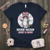 Rockin' Racoon Sweet & Sassy t-shirt design featuring a cute raccoon wearing sunglasses and a pink bow, holding a lollipop