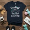 Rockin' the Cat Mom & Aunt Life text with two cats graphic on a navy t-shirt, adorned with floral accents