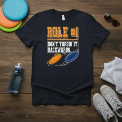 Rule #1 Don't Throw It Backwards text with orange and blue frisbee graphics on a navy t-shirt for disc golf