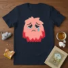 Sad Monster Graphic T-Shirt featuring a pink fluffy monster crying a single teardrop