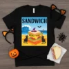 Sandwich Halloween Beach Cats T-Shirt design featuring a spooky sandwich, black cats, and a beach scene with a witch hat