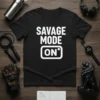 Black t-shirt with white "Savage Mode On" text and graphic, featuring workout accessories like dumbbells and headphones