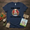 SAVE A COW EAT A VEGETARIAN text with a cartoon chef cow cooking in a pot on a navy t-shirt