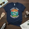 Save the Manatees text with illustration of manatees swimming in ocean sunset graphic on a navy blue t-shirt