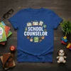 School Counselor t-shirt design with bold white text surrounded by school-themed icons like books, a globe, and diverse children's faces
