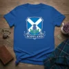 Scotland Thistle Shield T-Shirt featuring the Scottish flag and national flower, the thistle, on a blue background