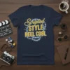 Scripted STYLE REEL COOL text design with film reel graphic on a navy t-shirt