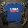 Blue t-shirt with "SCUBA PERIODICALY" text in periodic table elements design, scuba mask, snorkel, and fins shown around it