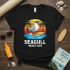 Seagull beach life quote on a black t-shirt with a cartoon seagull surfing at sunset