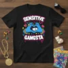 Sensitive Gangsta t-shirt with blue hands forming a heart around a sleeping kitten, featuring bold pink and white text