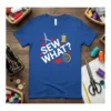 Blue t-shirt with white text "SEW WHAT?" surrounded by red hearts, scissors, a spool of thread, and a measuring tape