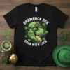 Shamrock Rex Roar With Luck T-Shirt design featuring a T-Rex dinosaur wearing a baseball cap and sunglasses with shamrocks