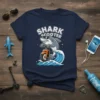 Shark Scooter T-Shirt design with a cartoon shark wearing sunglasses riding an orange scooter through blue waves