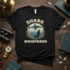 Black t-shirt with "Shark Whisperer" text and a graphic of a diver and shark underwater