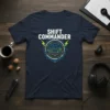 Navy blue t-shirt with "SHIFT COMMANDER" text and a circular futuristic control panel graphic with green and blue accents