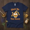 Show Me Your Honey t-shirt design with a cartoon bee on a honey pot and honeycomb accents