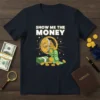 Show Me The Money quote t-shirt with a vault spilling cash and coins, designed for finance and wealth enthusiasts