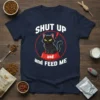 Shut Up and Feed Me quote with a grumpy black cat sitting in a food bowl on a navy t-shirt