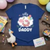 Silly Daddy t-shirt design featuring a goose wearing a party hat on a pink couch, holding balloons
