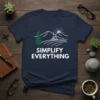 Simplify Everything t-shirt with a minimalist design of a mountain cabin, pine tree, and sun