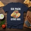 Six Pack Gyro Abs text with two gyro sandwiches graphic on a navy blue t-shirt