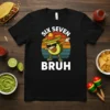 Black t-shirt with "SIX SEVEN BRUH" text and a dabbing avocado wearing a sombrero, with a vintage sunset background
