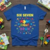 Blue t-shirt with "SIX SEVEN EIGHT BRUH" text in colorful puzzle pieces and fireworks graphic