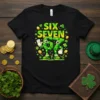 Black t-shirt with "SIX SEVEN" in yellow and green, featuring cartoon numbers 6 and 7 with shamrocks and gold coins