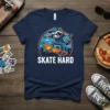 Skate Hard t-shirt with a cartoon raccoon on a skateboard, wearing a blue cap and jeans, with flames on the