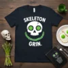 Skeleton Grin. text with a white skull and green eyes, smiling with an asparagus stalk grin on a black t-shirt