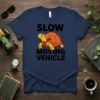 Slow Moving Vehicle t-shirt with a cartoon turtle wearing a bandana. Black text reads "SLOW MOVING VEHICLE" above and below
