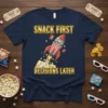 Snack First Decisions Later quote on a navy t-shirt with a popcorn rocket graphic and movie ticket accents