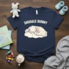 Snuggle Bunny text above a sleeping white bunny on a cloud graphic, on a navy blue t-shirt