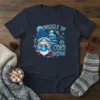 T-shirt with "SNUGGLE UP Gnomies IT'S COLD OUTSIDE" text, featuring a blue gnome holding hot cocoa, a winter tree, and