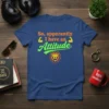 Blue t-shirt with orange and green text "So, apparently I have an Attitude" and a lion graphic