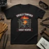 Black t-shirt with "Socially Tempered Easily Heated" text and a graphic of a blacksmith's forge, anvil, and hammers