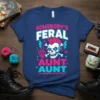 Somebody's Feral Aunt Aunt text with punk skull graphic, pink mohawk, and lightning bolts on a navy blue t-shirt