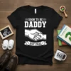 Soon To Be Daddy Est. 2022 T-Shirt design featuring bold white text and a graphic of a handshake between an