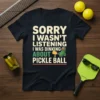 Sorry I Wasn't Listening I Was Dinking About Pickle Ball funny pickleball t-shirt design with a cartoon pickle character